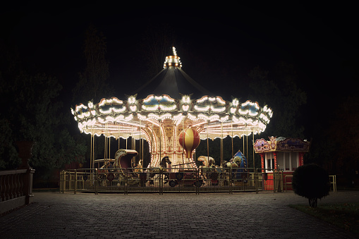 Old fashioned carousel backlit in a night park. Kharkov, Gorky Park.