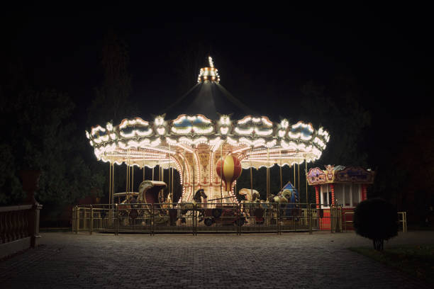 старомодная карусель подсветка в ночном парке. харьков, парк горького. - аттракцион карусель стоковые фото и изображения