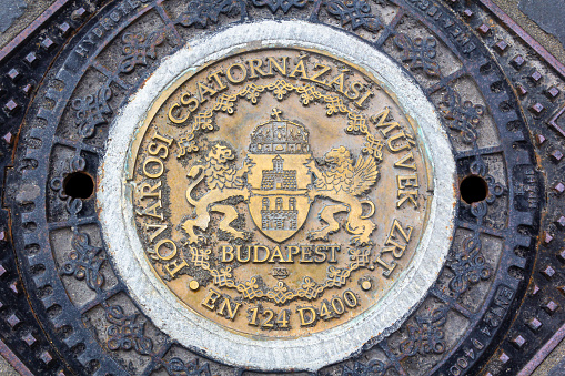 Manhole cover with coat of arms in the streets of Budapest, Hungary