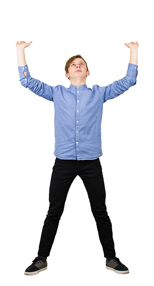 Determined teenage guy making effort as holding an heavy invisible object about to collapse squeeze him isolated on white background. Confident boy, difficult task concept, convinced in his powers.