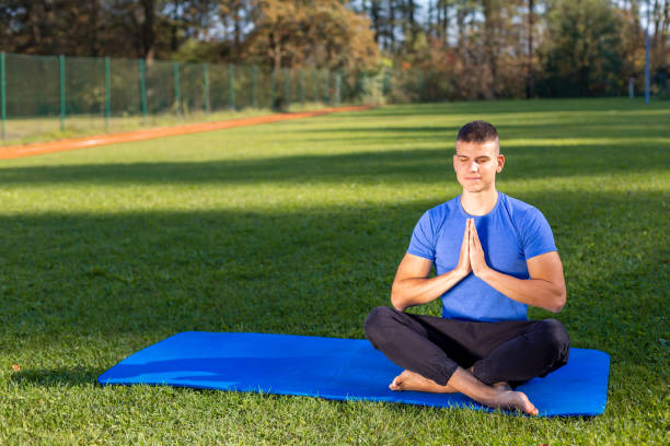 istock Man in park doing yoga 1186773532
