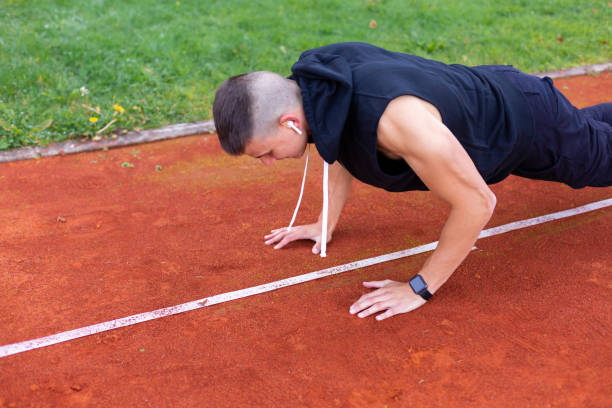 istock Man doing push upson the race track 1186773716