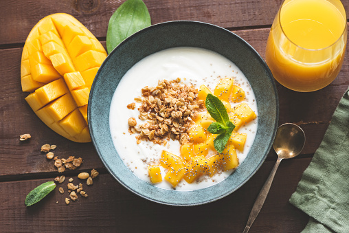 Yogurt bowl with mango and breakfast cereals oat granola