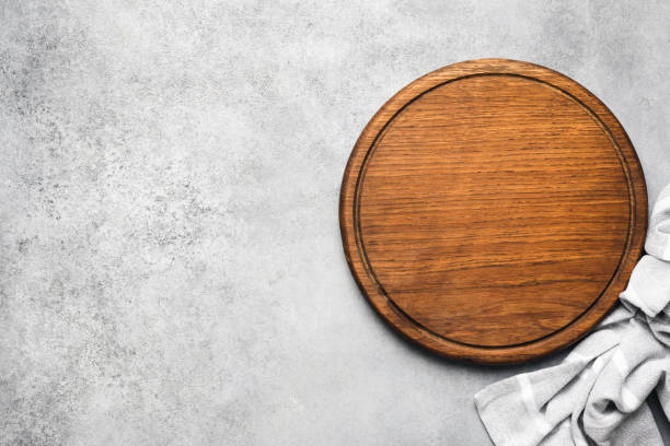 회색 콘크리트 배경에 둥근 나무 피자 보드 - tray table 뉴스 사진 이미지