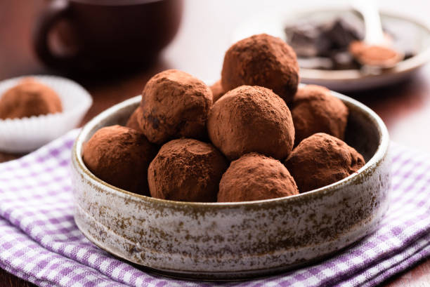 Chocolate truffles in ceramic dish Chocolate truffles in ceramic dish on table. Homemade chocolate candy truffles chocolate truffle stock pictures, royalty-free photos & images