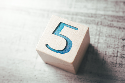 The Number 5 On A Wooden Block On A Table