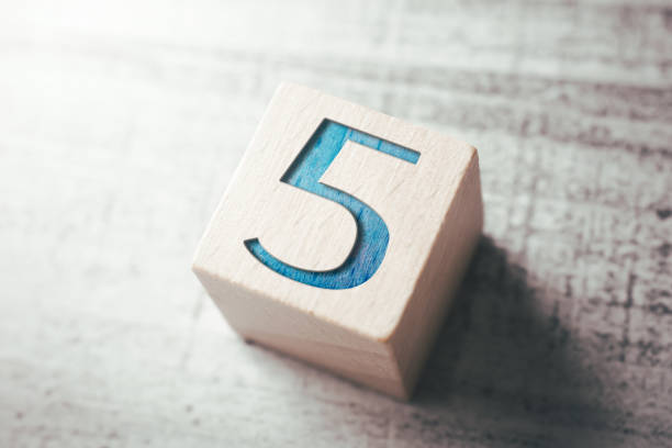 number 5 on a wooden block on a table - minute hand fotos imagens e fotografias de stock