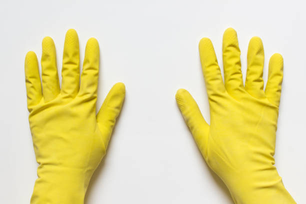 istock Two hands in yellow rubber latex gloves on white background 1186775955