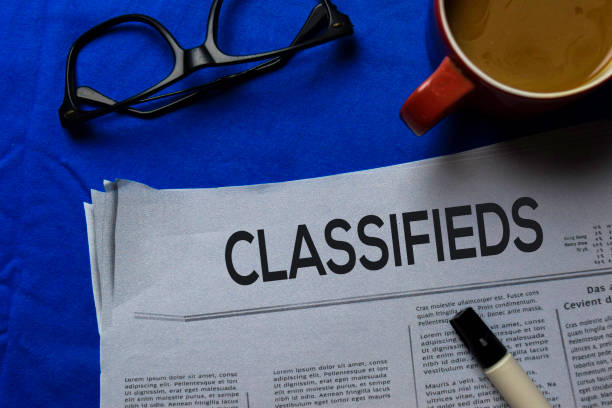 istock Classifieds text in headline isolated on blue background. Newspaper concept 1186776997