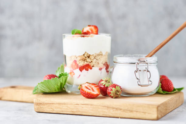 granola lub jogurt z truskawką w szkle, świeże jagody i słoik z cukrem na desce do krojenia - jar oatmeal granola glass zdjęcia i obrazy z banku zdjęć