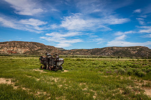 An abandoned antique threshing machine sits along the roadway in the shadow of the Laramie Mountains in Wyoming.