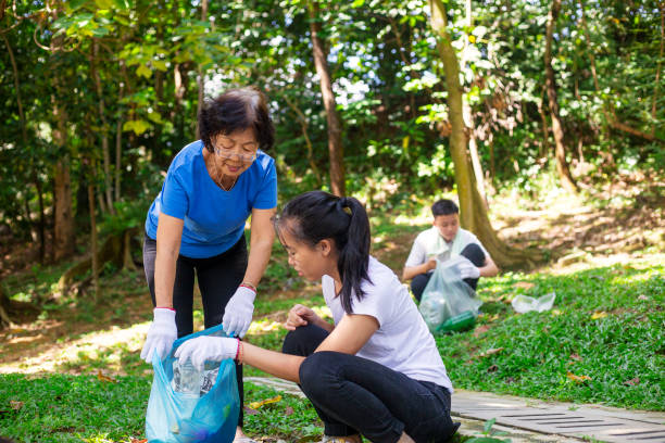 children doing community service project with grandmother at publiic park - volunteer senior adult teenager occupation imagens e fotografias de stock