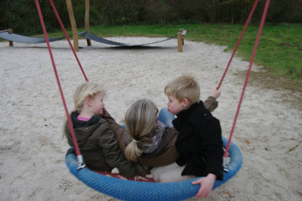 Swing set playing family in the autumn forest