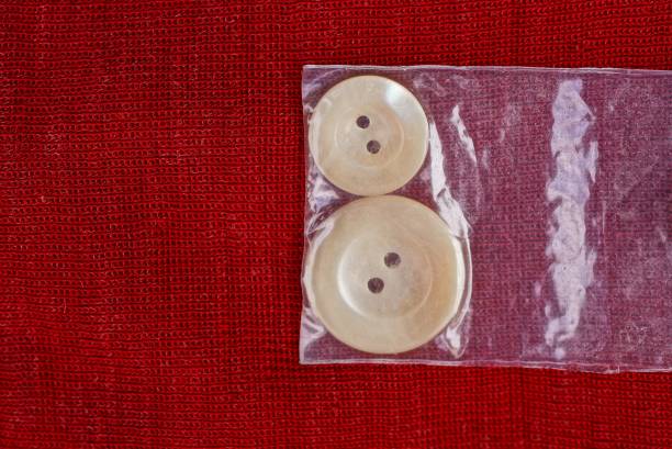 istock plastic gray buttons in a bag lies on a red cloth 1186788186