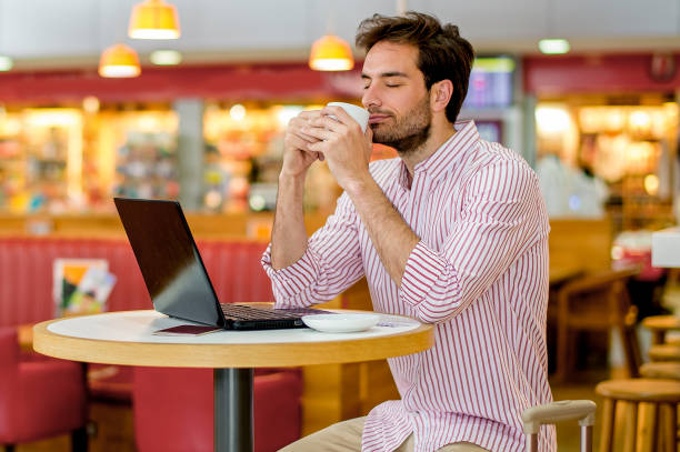 young amazon seller using laptop while drinking coffee in a cafe