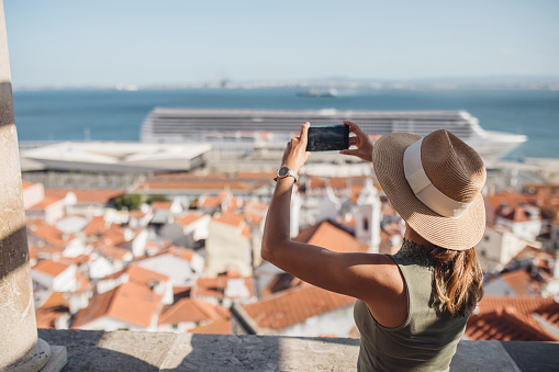 Young female tourist taking photos of Lisbon