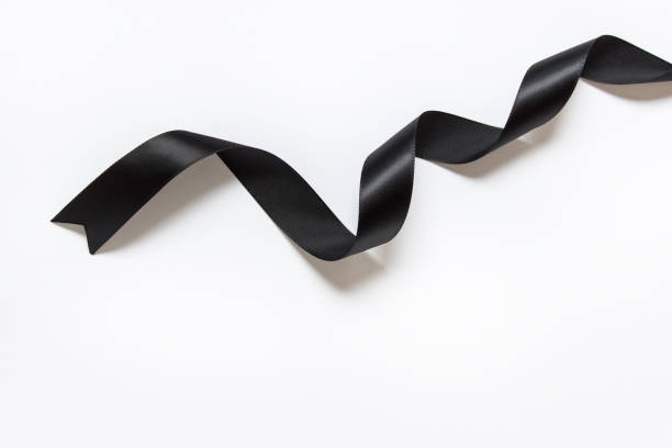 Black silky ribbon with twists on white background stock photo