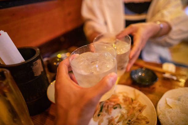 Celebratory toast with Japanese 'Awamori' alcohol in Okinawa, Japan Celebratory toast with Japanese 'Awamori' alcohol in Okinawa, Japan saki photos stock pictures, royalty-free photos & images