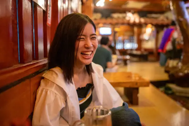Happy young woman in Japanese 'Izakaya' restaurant