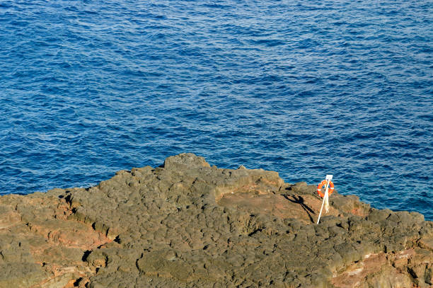 lifebuoy su una costa rocciosa sull'isola di la palma - rocky coastline spain la palma canary islands foto e immagini stock