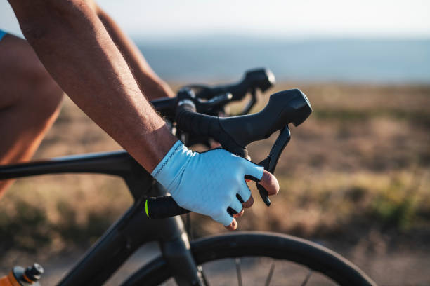 Cycling outdoors. Athlete on racing bike outdoors at sunset, close-up extreme dedication stock pictures, royalty-free photos & images