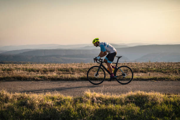 Cycling outdoors. Athlete on racing bike outdoors at sunset. triathlon stock pictures, royalty-free photos & images