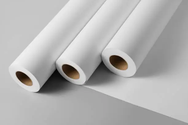 Photo of Blank white paper rolls mockup isolated on gray background