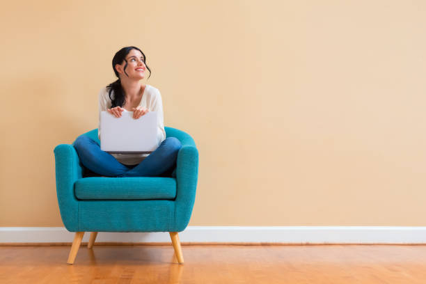 istock Young woman with a laptop computer in a thoughtful pose 1186815550