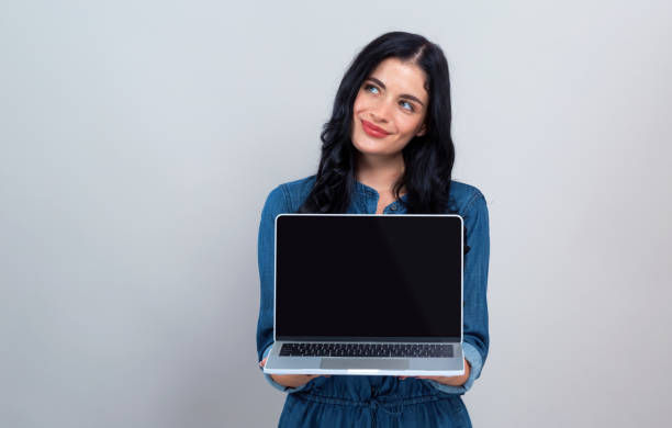 istock Young woman with a laptop computer in a thoughtful pose 1186816583