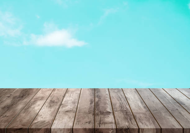 vintage empty aged dark brown wood panel perspective template above blue sky background and white clouds texture with pastel tone color for advertising product design on display with copy space