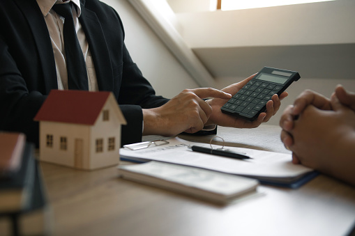 Agents are calculating the loan payment rate or the amount of insurance premiums for customers coming to contact the purchase of a new home at the office.