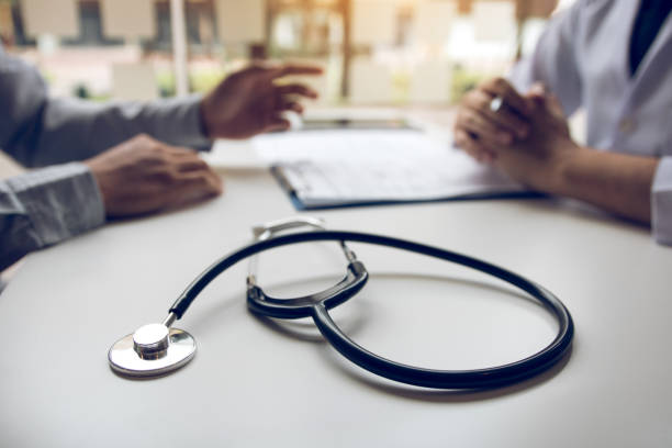 istock Close up stethoscope and doctor talking the patient at clinic while using the tablet explaining the patient condition and the treatment result. 1186822592