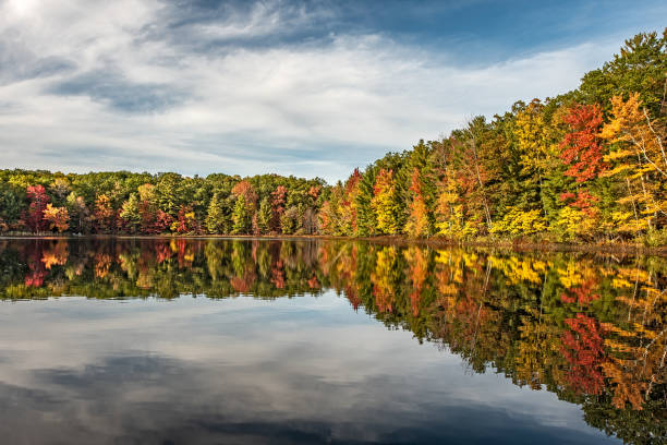 istock Autumn Reflections in a Calm Lake with Blue Sky and Clouds 1186836654