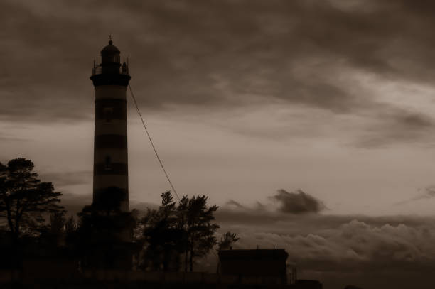 istock High lighthouse tower silhouette in the dark 1186837696
