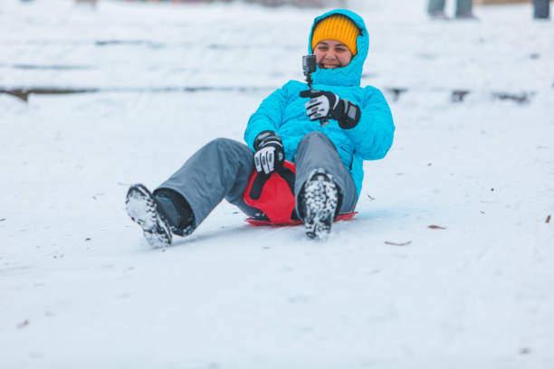 istock young woman sliding down by snowed hill copy space 1186842640