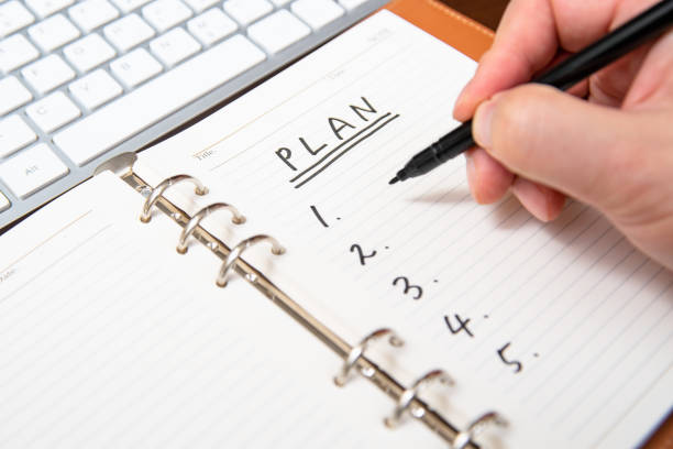 istock Close-up of a businessman's hand writing plan and list in the diary. 1186844321