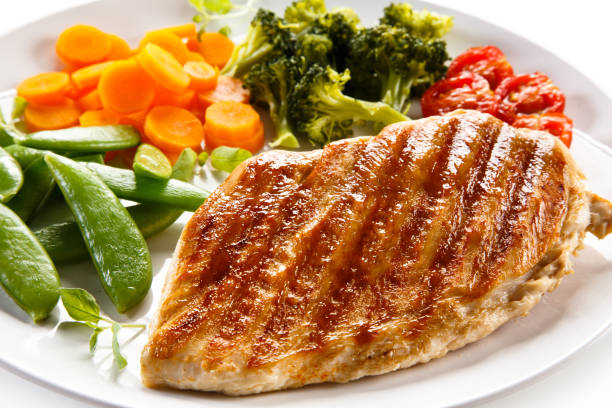 istock Grilled chicken breast with vegetable salad on white background 1186850406