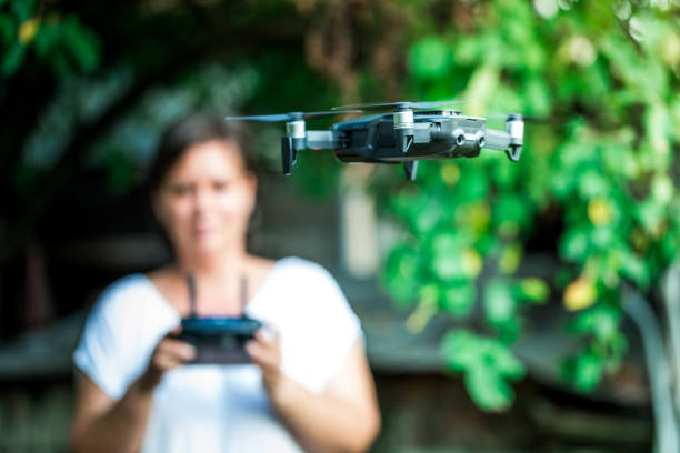 jovem mulher voando dji mavic air drone quadcóptero ao ar livre na natureza - drone subindo - fotografias e filmes do acervo
