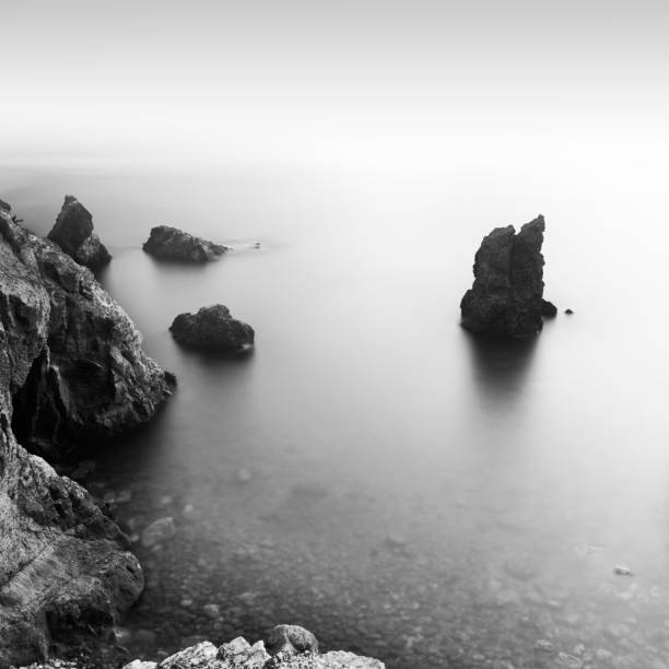 exposição longa da rocha solitária no mar no cabo kogane, prefeitura de shizuoka, japão - black and white landscape square long exposure - fotografias e filmes do acervo