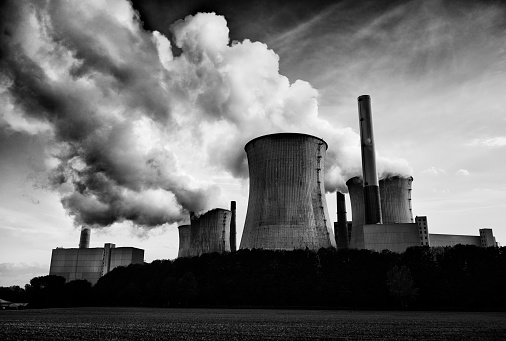 Black and white high resolution photograph of a brown-coal burning power plant with pollution.