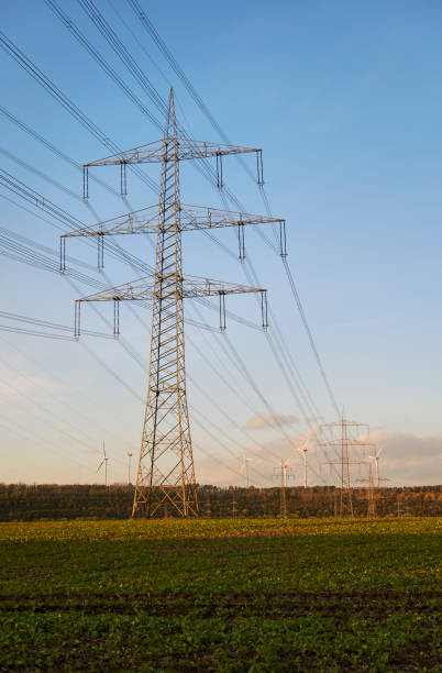 istock Electricity pylon and wind turbines 1186859234