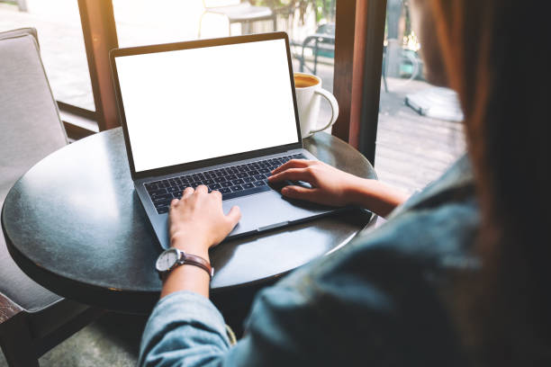 istock a woman using and typing on laptop with blank white desktop screen with coffee cup on the table 1186859953