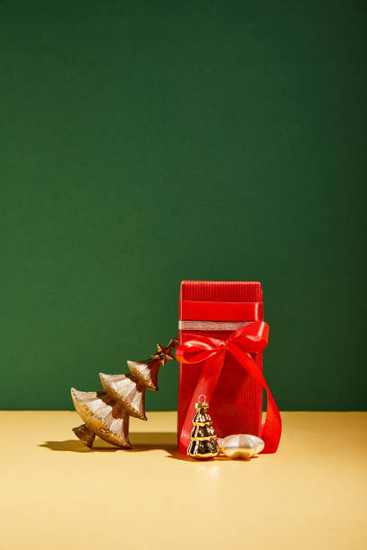 istock red gift box and decorative Christmas tree with golden baubles on green background 1186863461