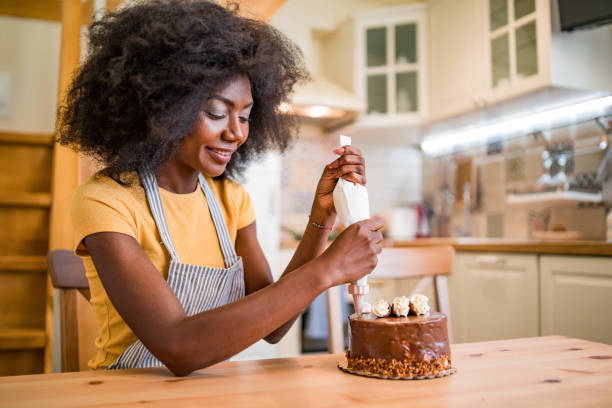 istock Afro women decorating a cake at home 1186863681