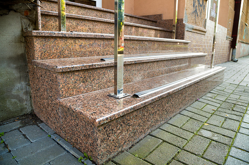Detail of a house facade. New granite stairs with metal railings.