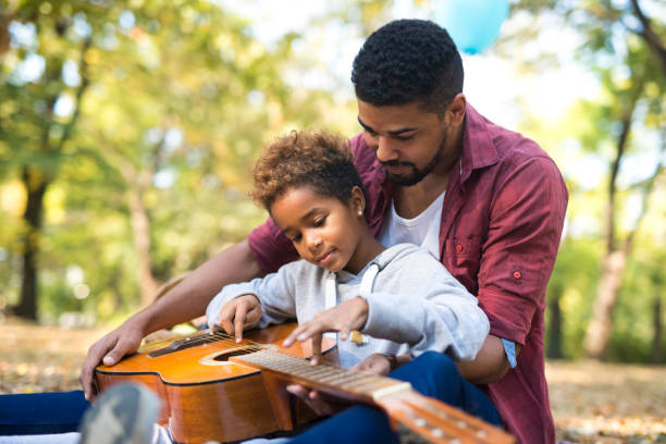 miłość jest w powietrzu. ojciec i córka grają razem na gitarze. - guitar child music learning zdjęcia i obrazy z banku zdjęć