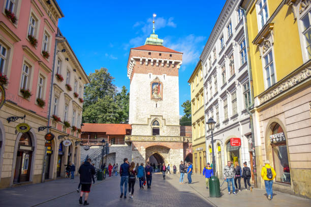 Tourists and locals spending their time at St. Florian's Gate, the Polish gothic city defense walls with medieval towers and a focal point of Krakow, Poland