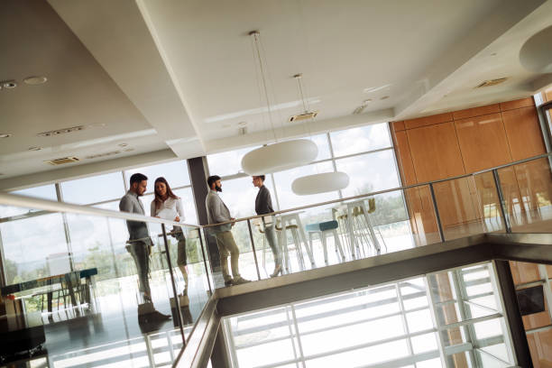 istock Business people discussing over documents in office lobby. 1186873627