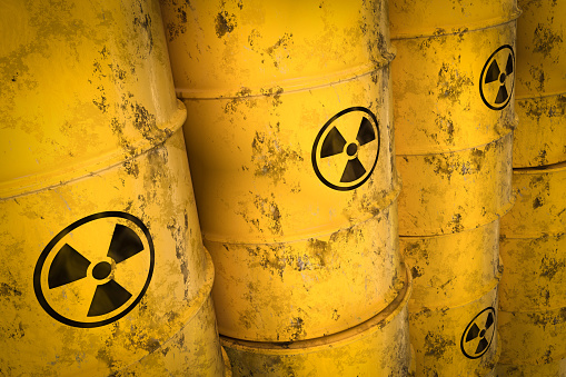 Yellow radioactive waste barrels - nuclear waste dumping concept. 3D rendered illustration.