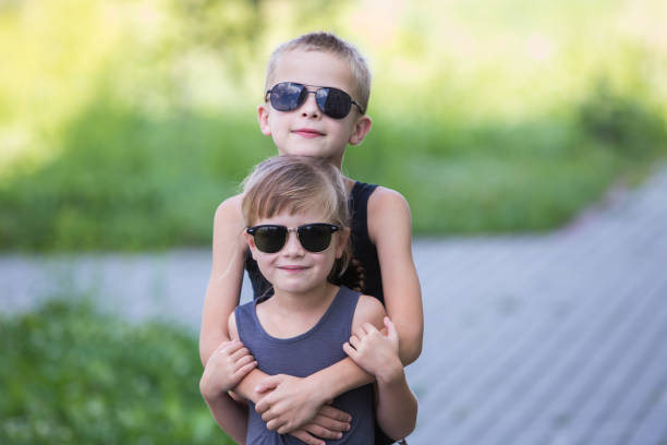 istock Two children in black sunglasses having fun time outdoors in summer. 1186875344